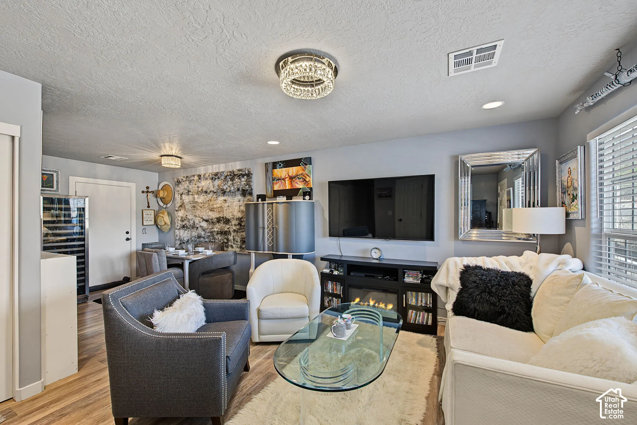 Recessed lighting, wood-finish flooring, built-in electric fireplace, contemporary light fixtures, and a prominent window