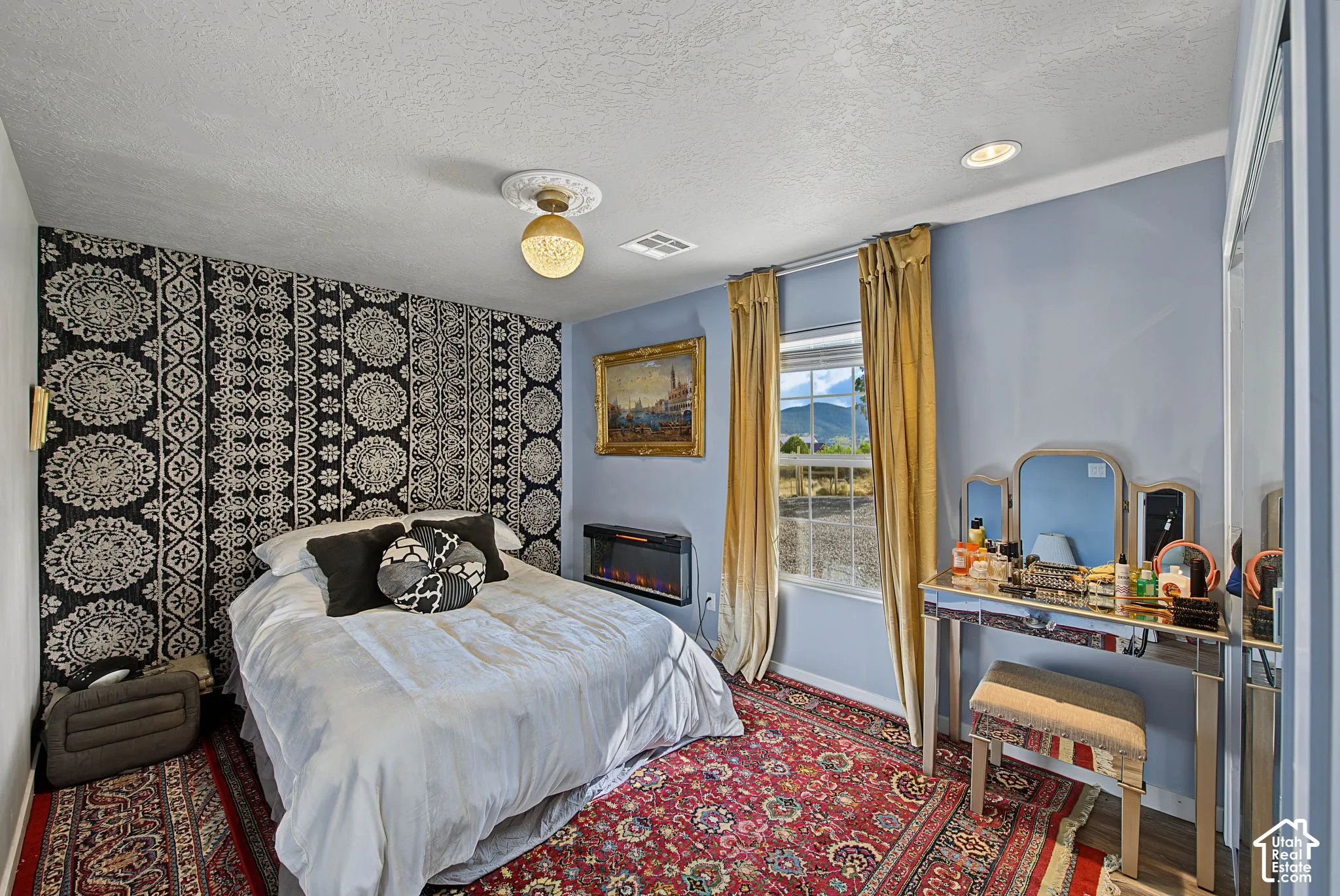 Recessed lighting, window with exterior scenery, built-in electric fireplace, overhead decorative light fixture, patterned accent wall