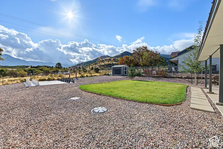 Expansive outdoor area featuring a gravel ground cover, a manicured lawn area, and a detached shed