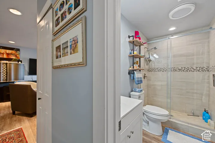Walk-in shower with clear glass enclosure, tiled walls, and decorative mosaic band