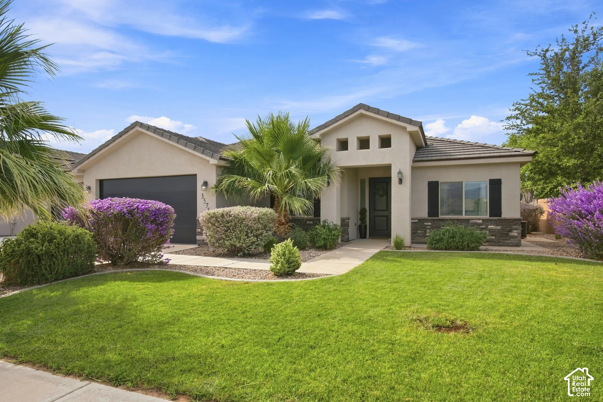 Stucco exterior featuring a tiled roof and stone accents