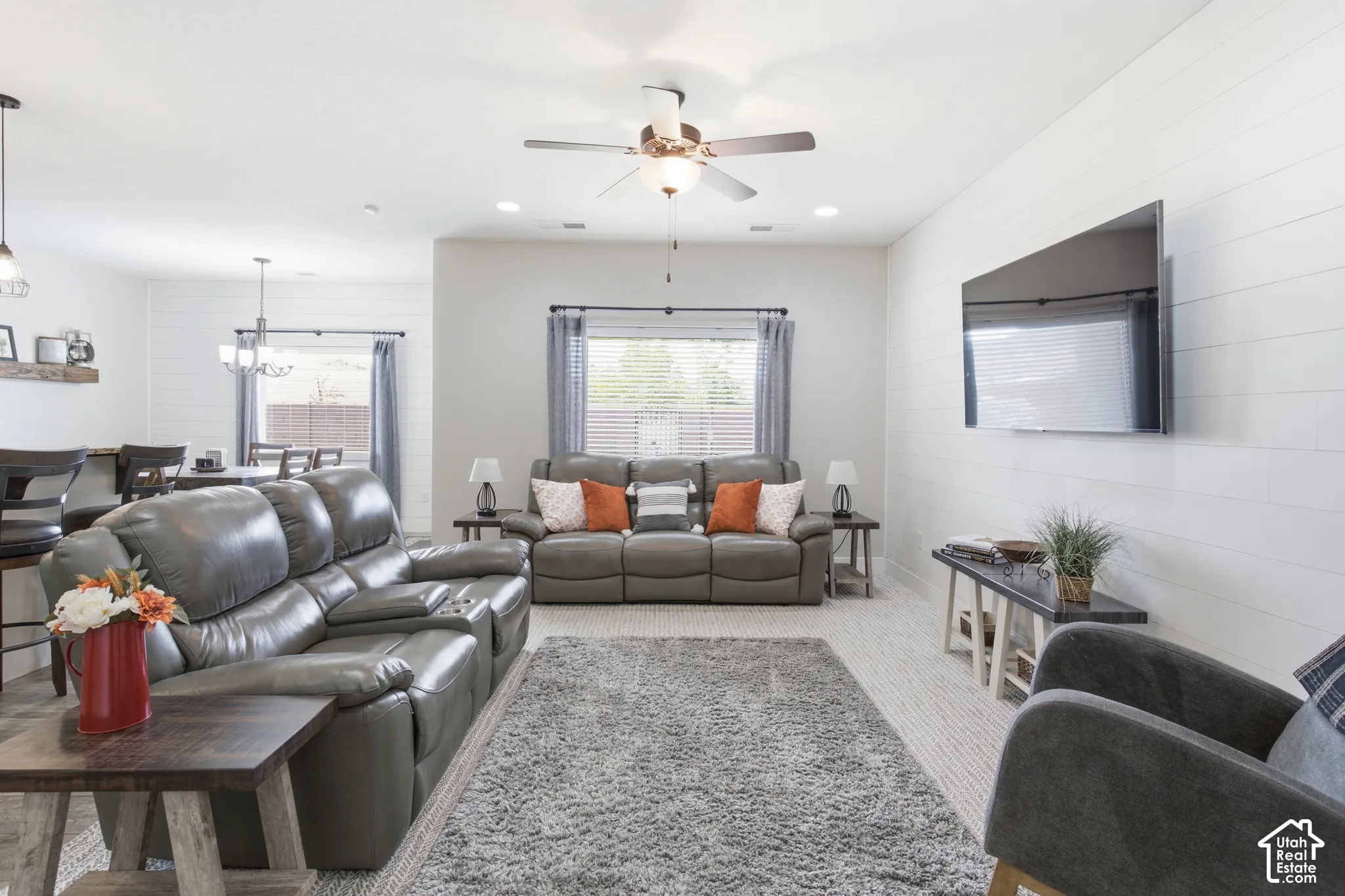 Living area featuring a ceiling fan, recessed lighting, white shiplap accent wall, and light-toned carpeting