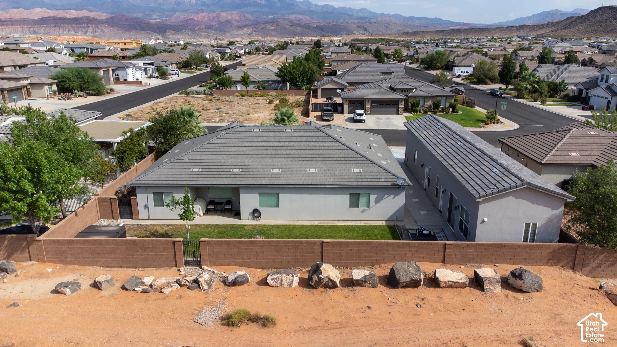 Two contemporary residences with light gray stucco exteriors and gray tile roofing