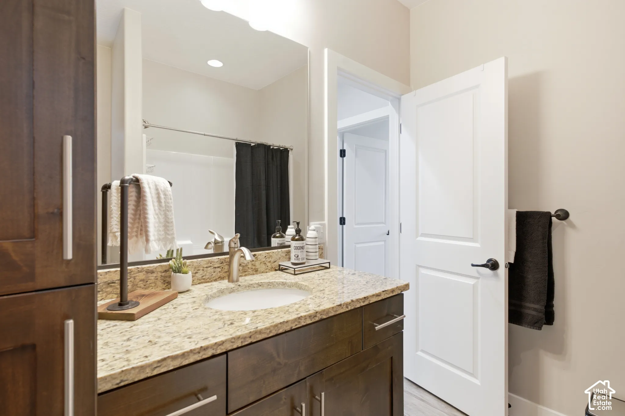 Spacious bathroom vanity with a granite countertop, undermount sink, and brushed nickel faucet