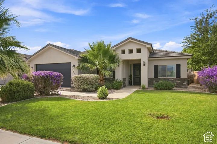 Stucco exterior featuring a tiled roof and stone accents
