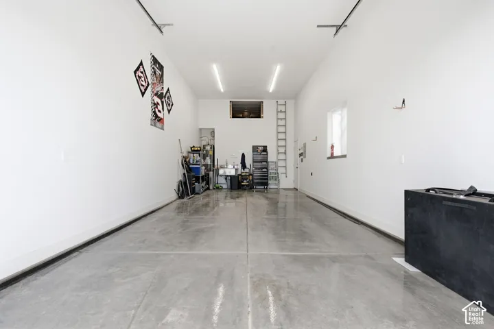 Expansive garage with polished concrete flooring, white painted walls, and overhead strip lighting