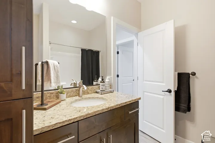 Spacious bathroom vanity with a granite countertop, undermount sink, and brushed nickel faucet