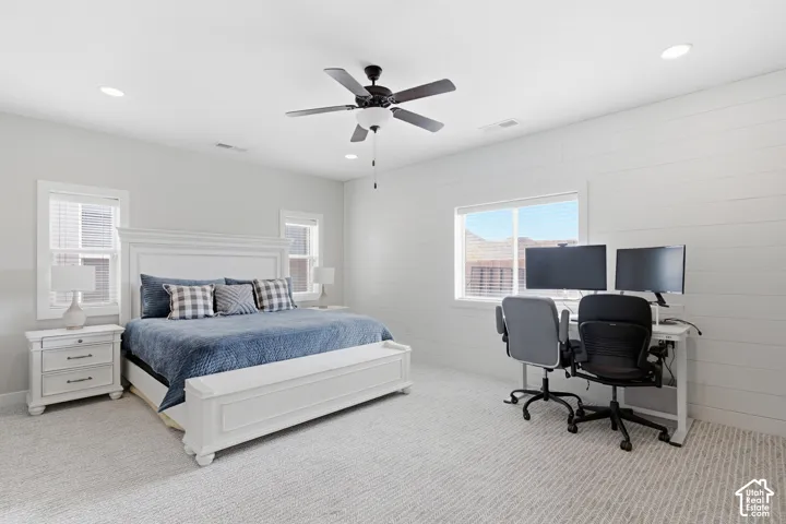 Recessed lighting, ceiling fan, shiplap accent wall, multiple windows, and carpeted flooring