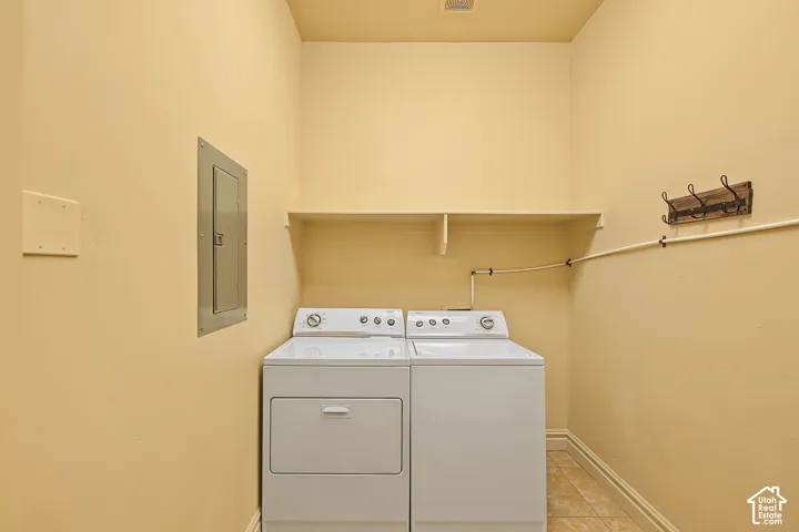 Utility area featuring a built-in shelf, tiled flooring, and a circuit breaker panel