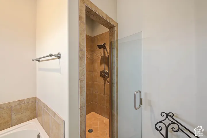 Shower with glass enclosure, tile surround, and an integrated showerhead