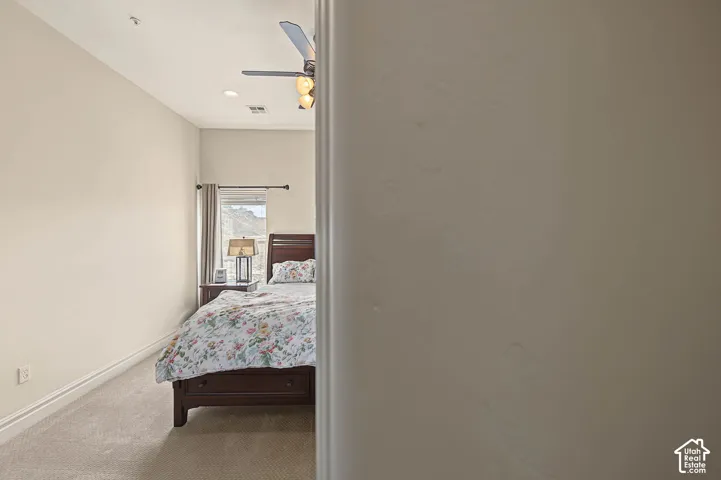 Recessed lighting, ceiling fan, window with curtain, and carpeted flooring