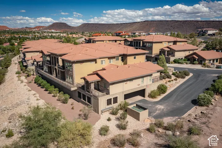 Terracotta-tiled roofs, multi-level structures, arid landscaping, and a paved driveway