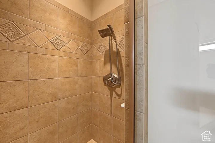 Tiled shower with decorative accent band, complete with a brushed nickel showerhead and control
