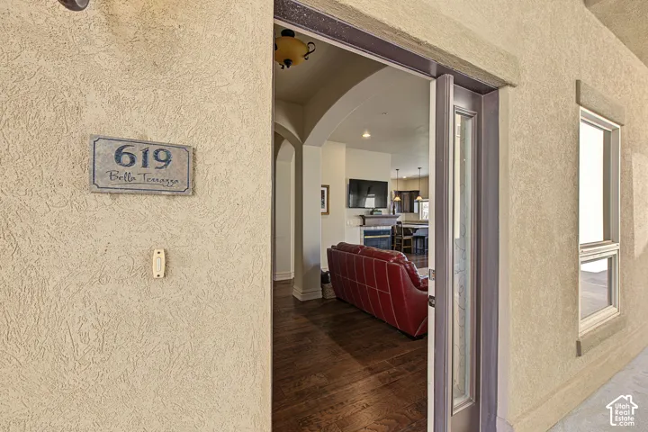 Stucco exterior with a decorative address plaque, doorbell, and a full-light entry door