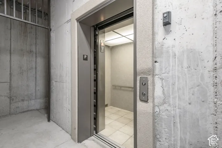 Automatic elevator access with tiled flooring and a handrail