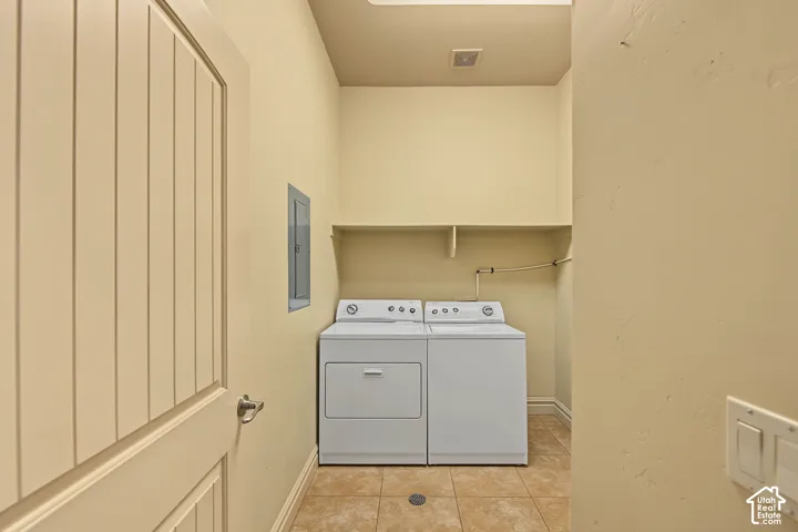 Laundry area featuring tile flooring and built-in shelving