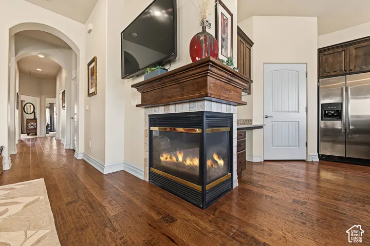 Gas fireplace with a wood mantel, tile surround, and stainless steel appliances