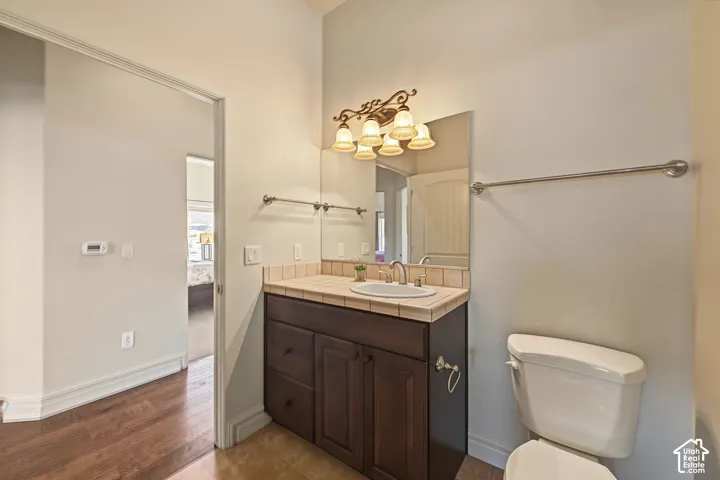 Dark wood-finish vanity with an integrated sink, tile countertop, and matching tile backsplash