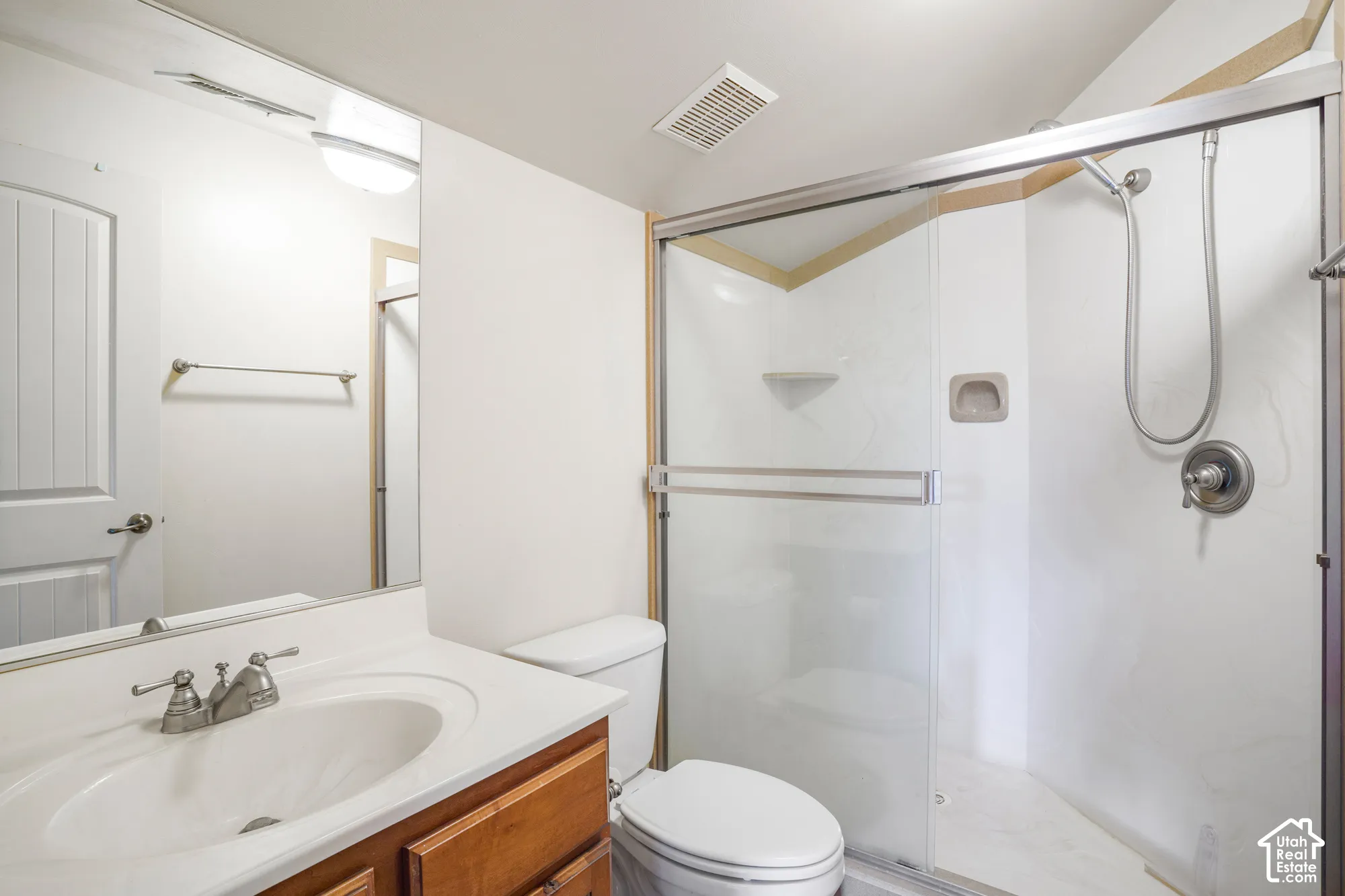 Vanity with integrated sink, wood-finish cabinetry, and chrome faucet