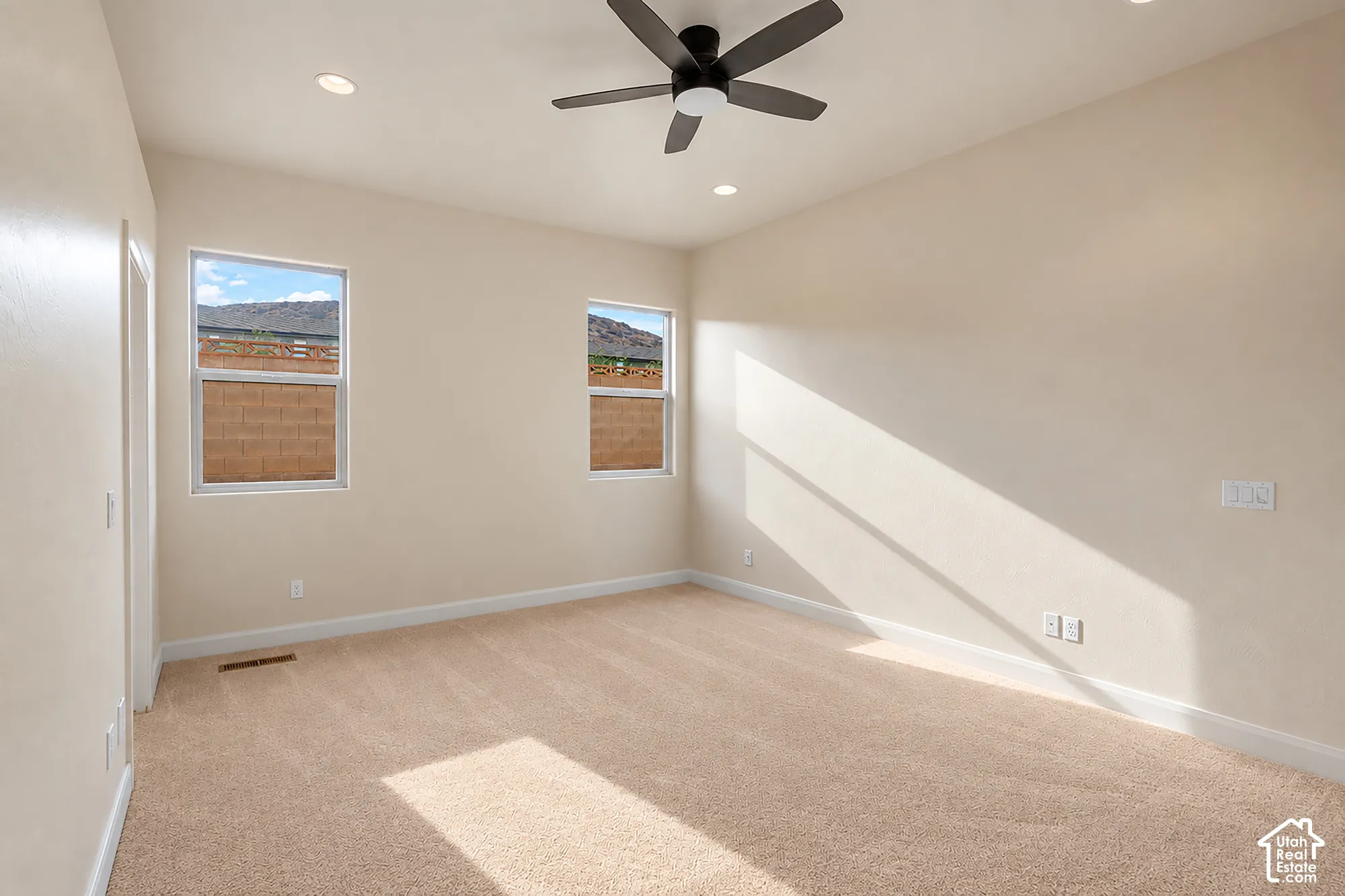 Recessed lighting, ceiling fan, and light-toned carpeting