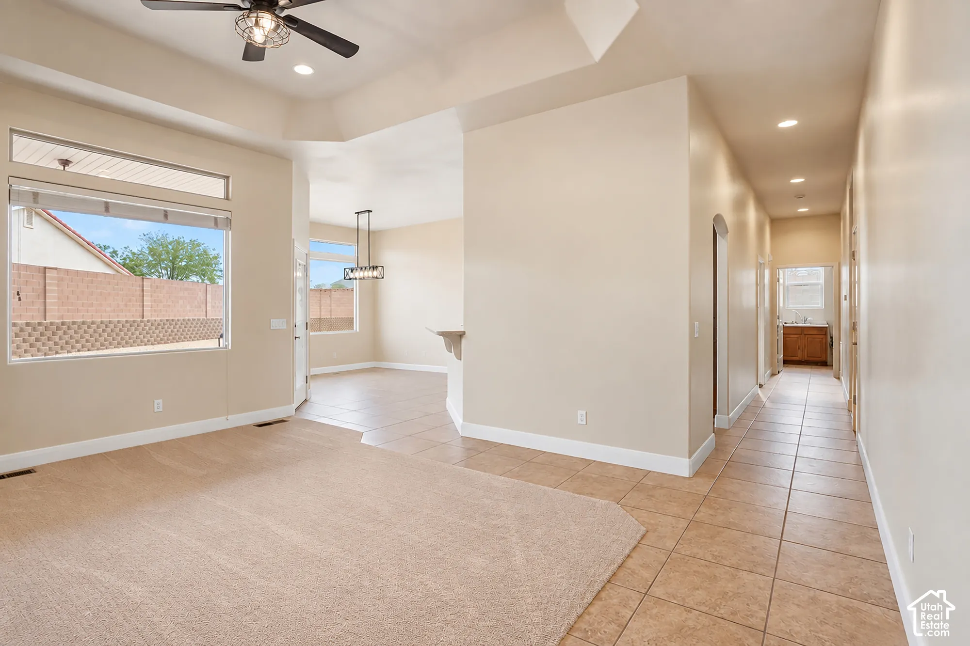 Vaulted ceiling with a ceiling fan, recessed lighting, and a transom window