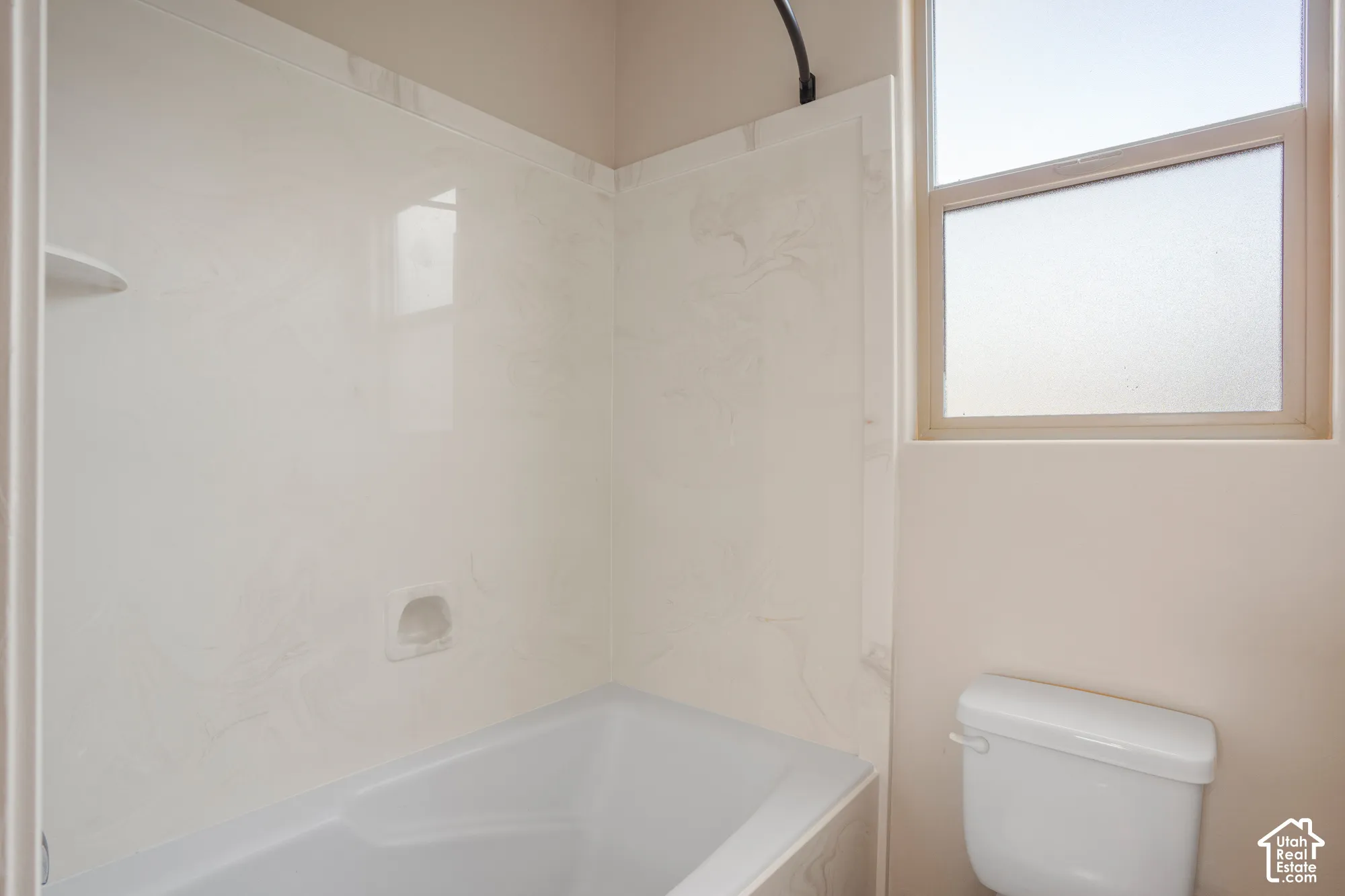 Bathtub with integrated shower surround, built-in soap dish, and an acrylic finish