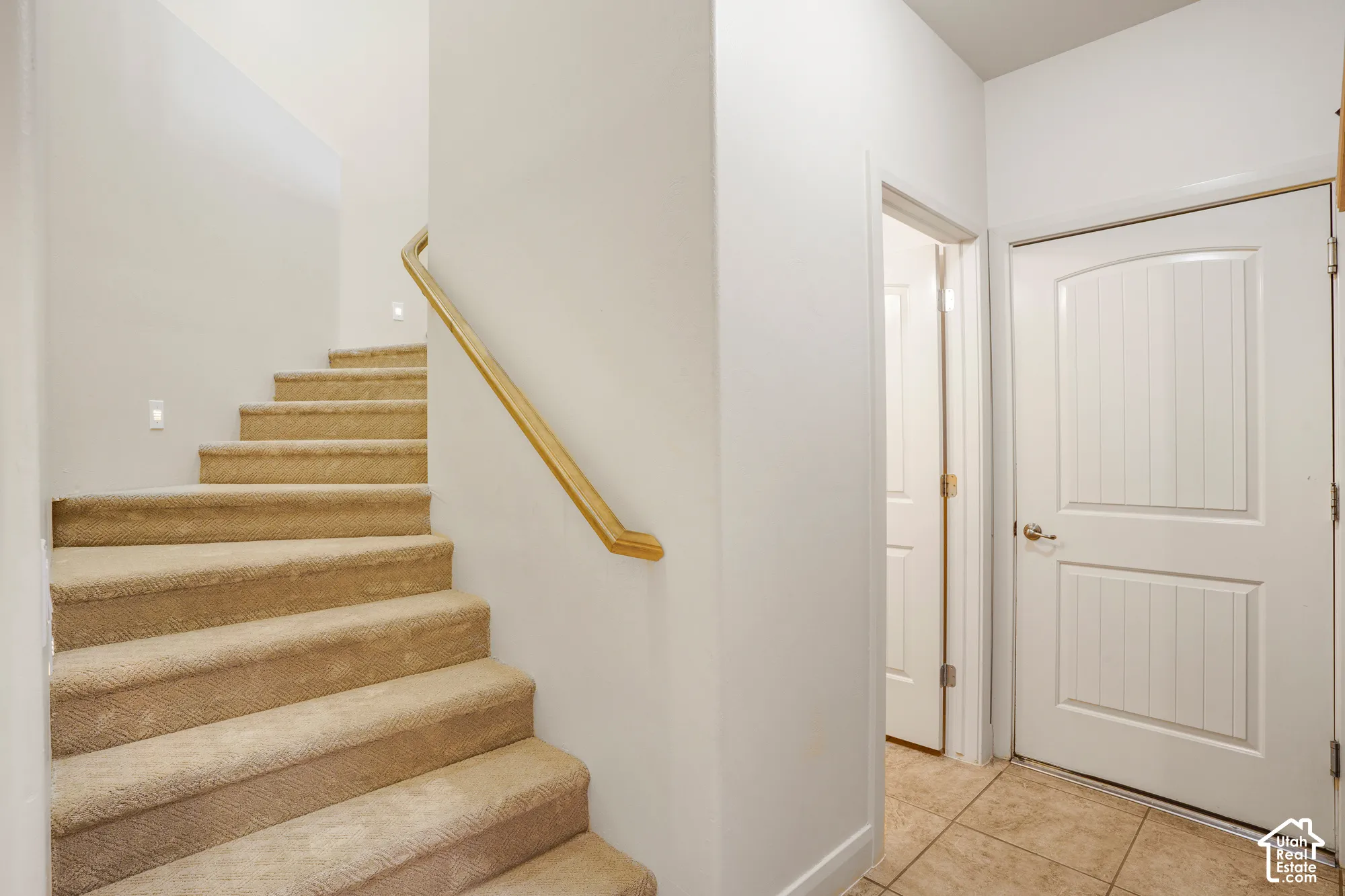 Curved staircase with carpeted treads and a wood handrail
