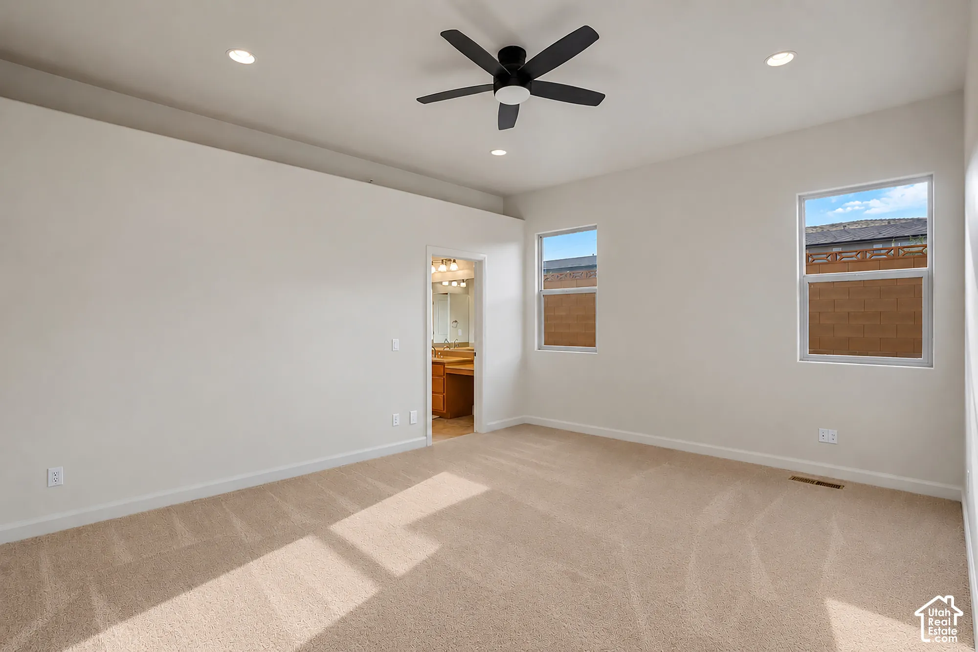 Recessed lighting, ceiling fan, two windows, and carpet flooring
