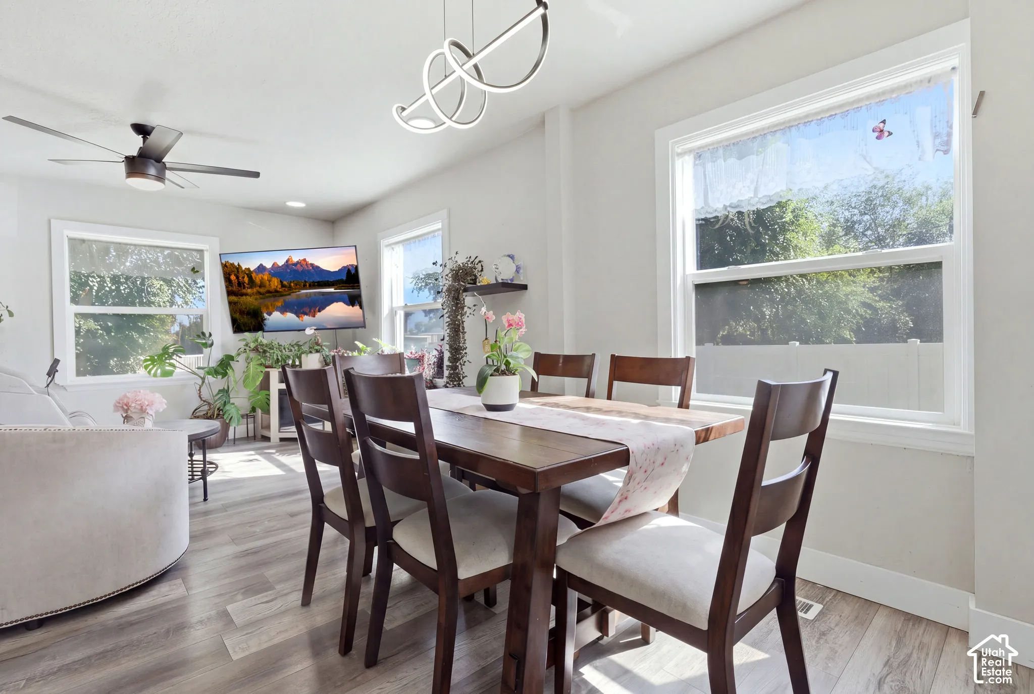 Recessed lighting, contemporary chandelier, wood-finish flooring, ceiling fan, and multiple windows