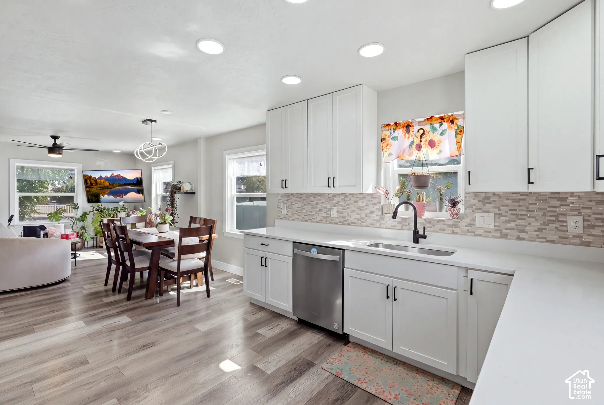 White shaker cabinetry with black hardware, stainless steel dishwasher, and a rectangular sink with a matte black faucet