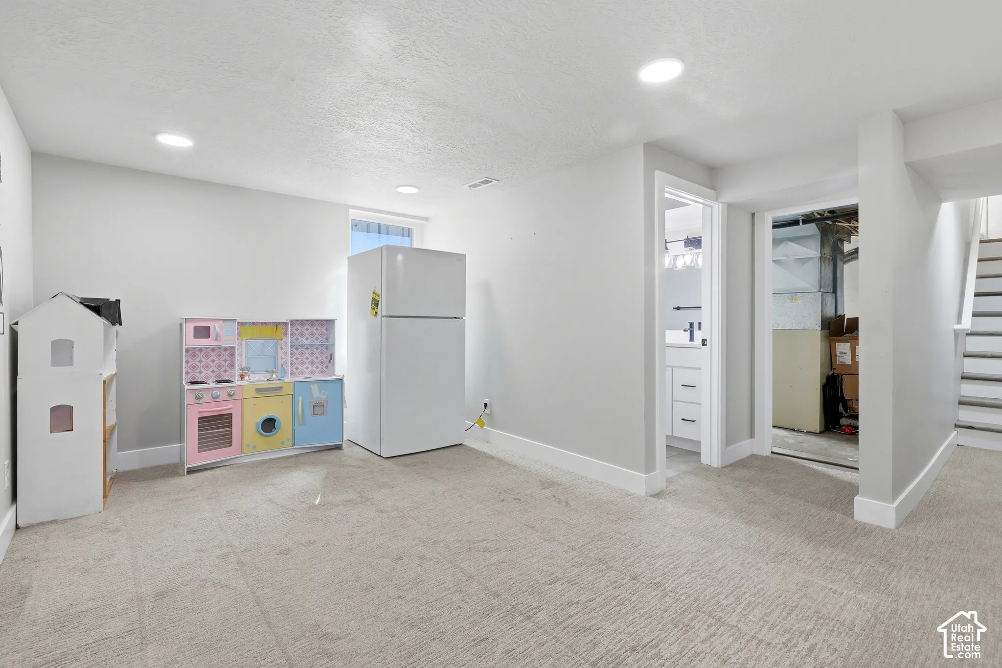 Recessed lighting, wall-to-wall carpeting, and a white interior paint scheme
