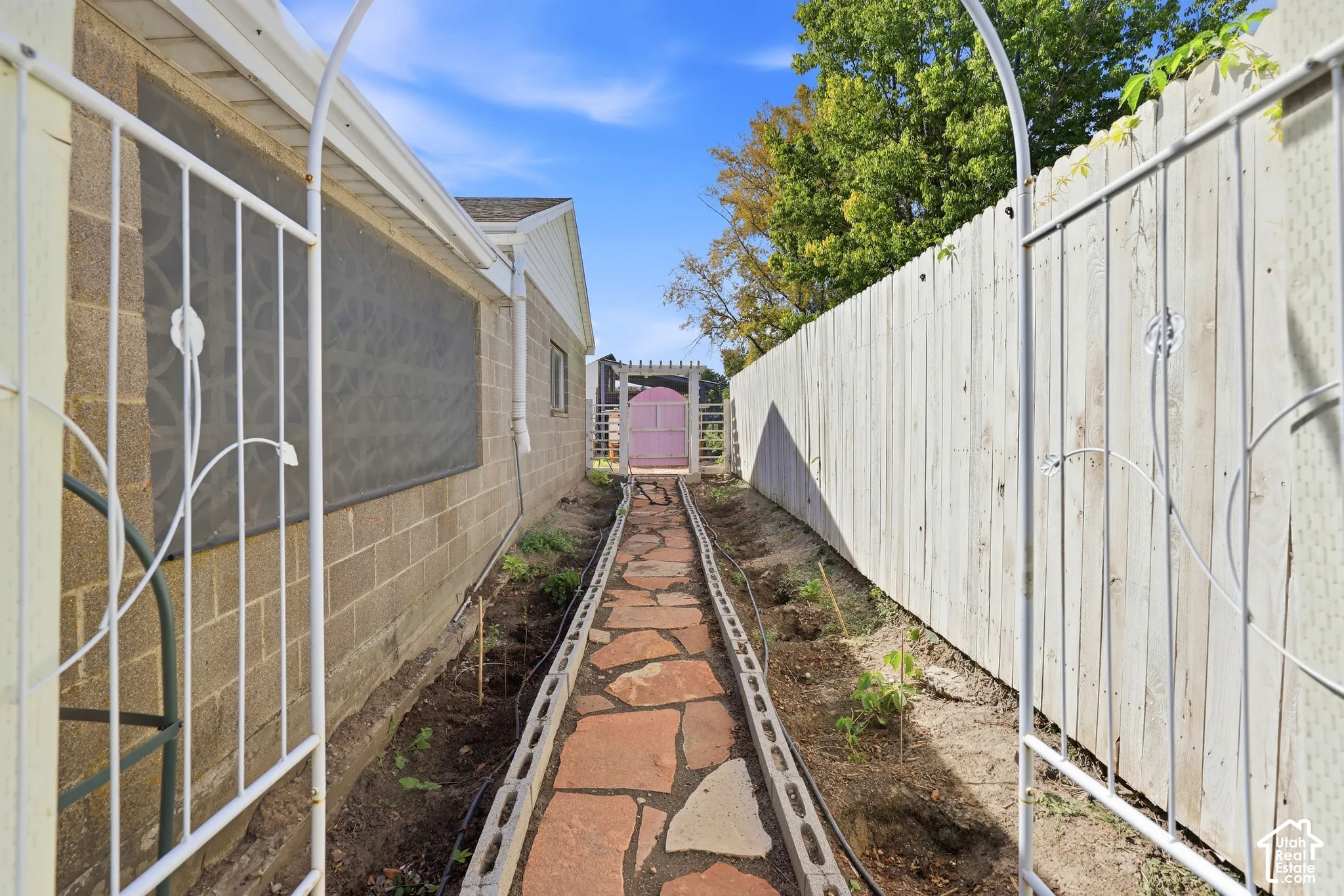 Wrought iron garden archway leading to a stone pathway