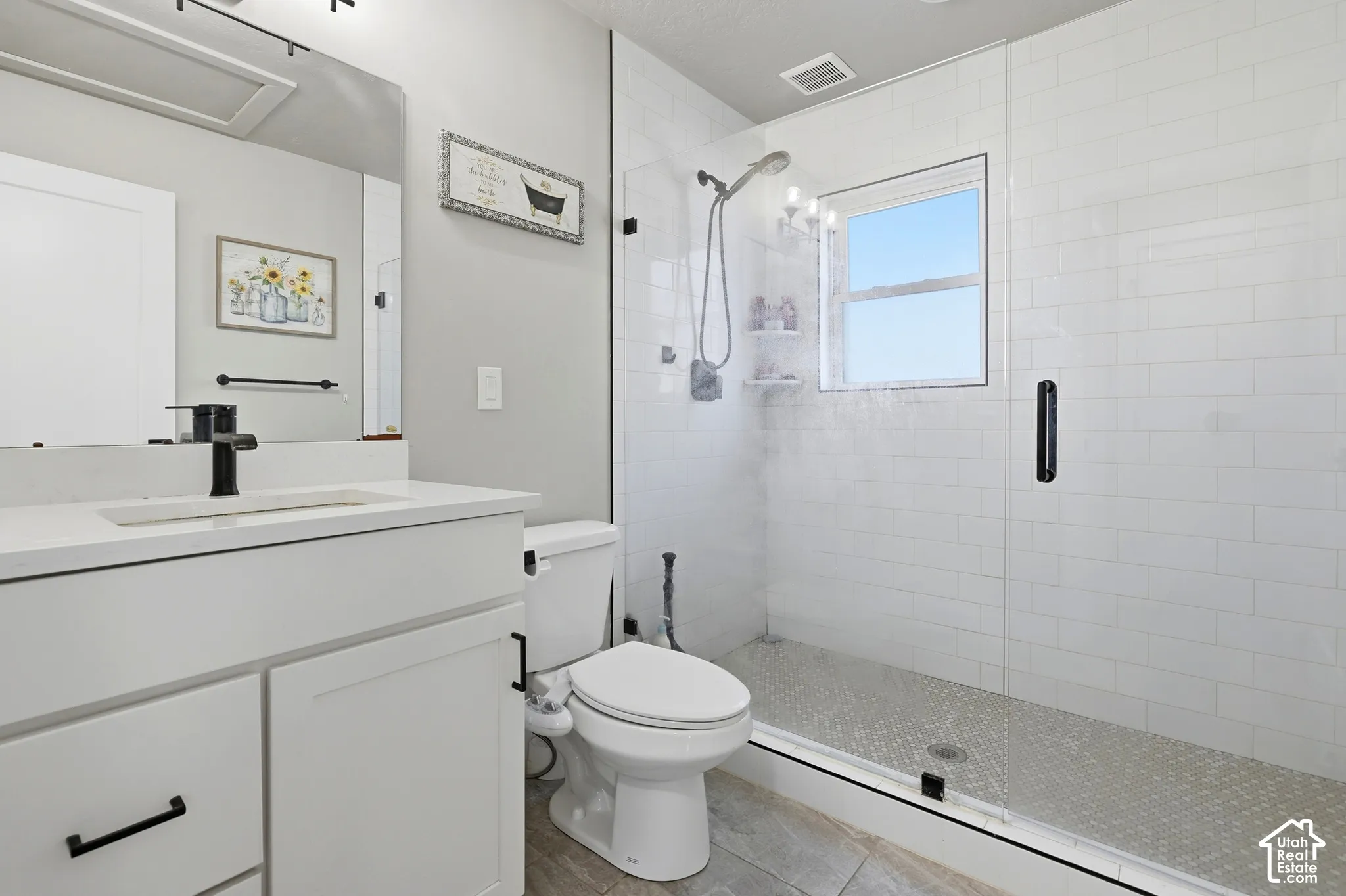White shaker cabinetry with black hardware, white countertop, and integrated sink