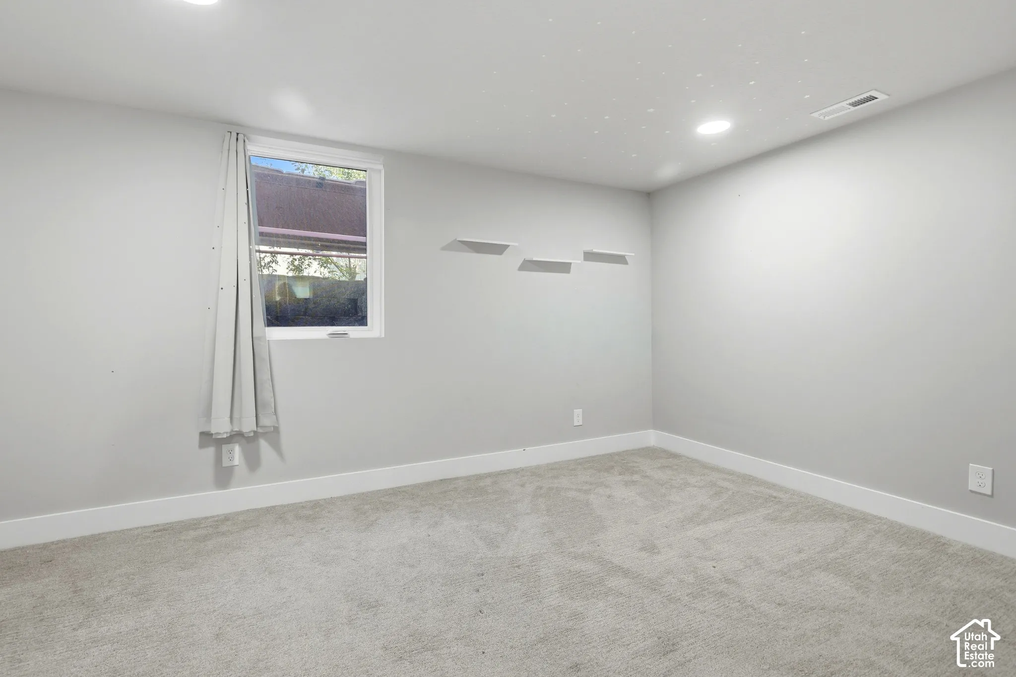 Recessed ceiling lighting, light gray wall finish, white window trim, white baseboards, and light gray carpeting