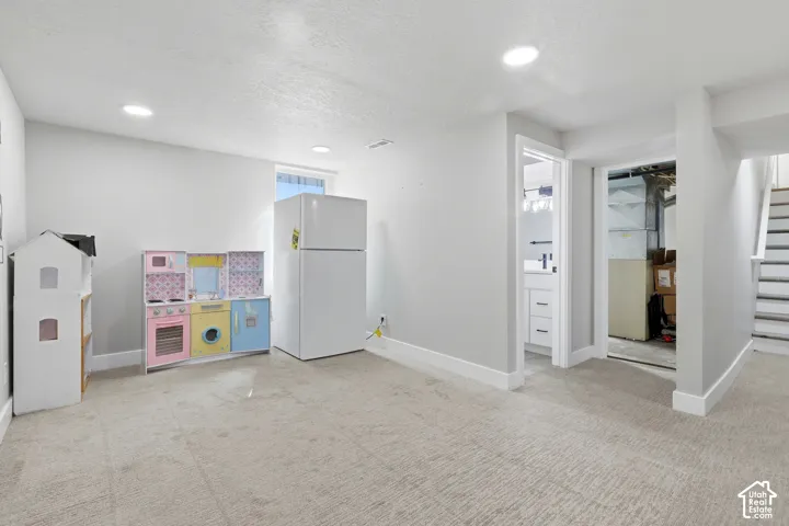 Recessed lighting, wall-to-wall carpeting, and a white interior paint scheme
