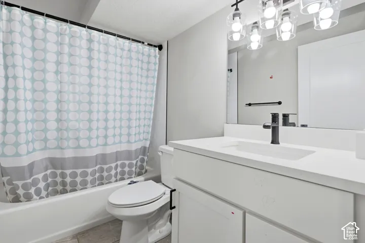 White vanity with integrated sink, black faucet, and overhead lighting fixture
