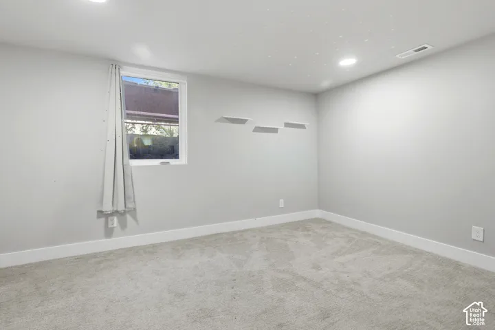 Recessed ceiling lighting, light gray wall finish, white window trim, white baseboards, and light gray carpeting