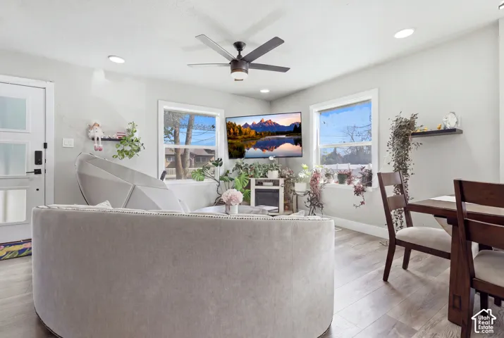 Recessed lighting, wood-finish flooring, white trim windows, and a ceiling fan create a bright interior