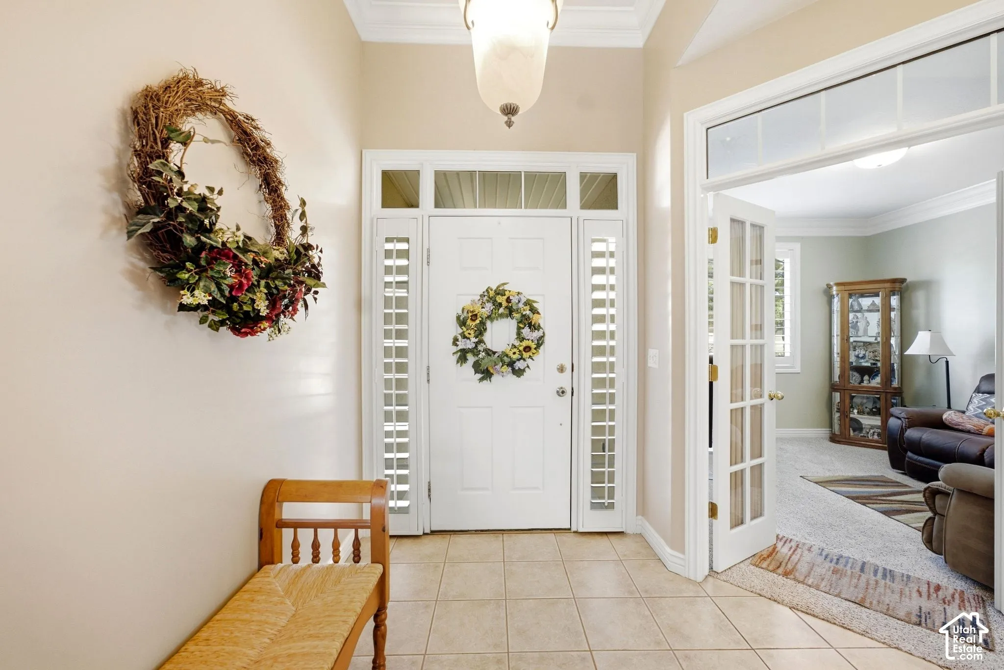 Entryway featuring large format tiled flooring, a white front door with sidelights, and a transom window