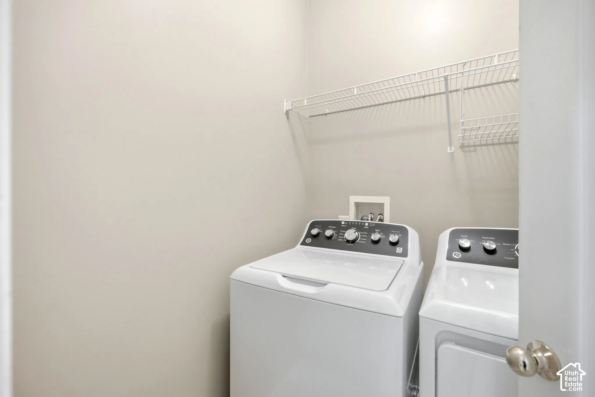 Laundry area featuring neutral wall paint and wire shelving