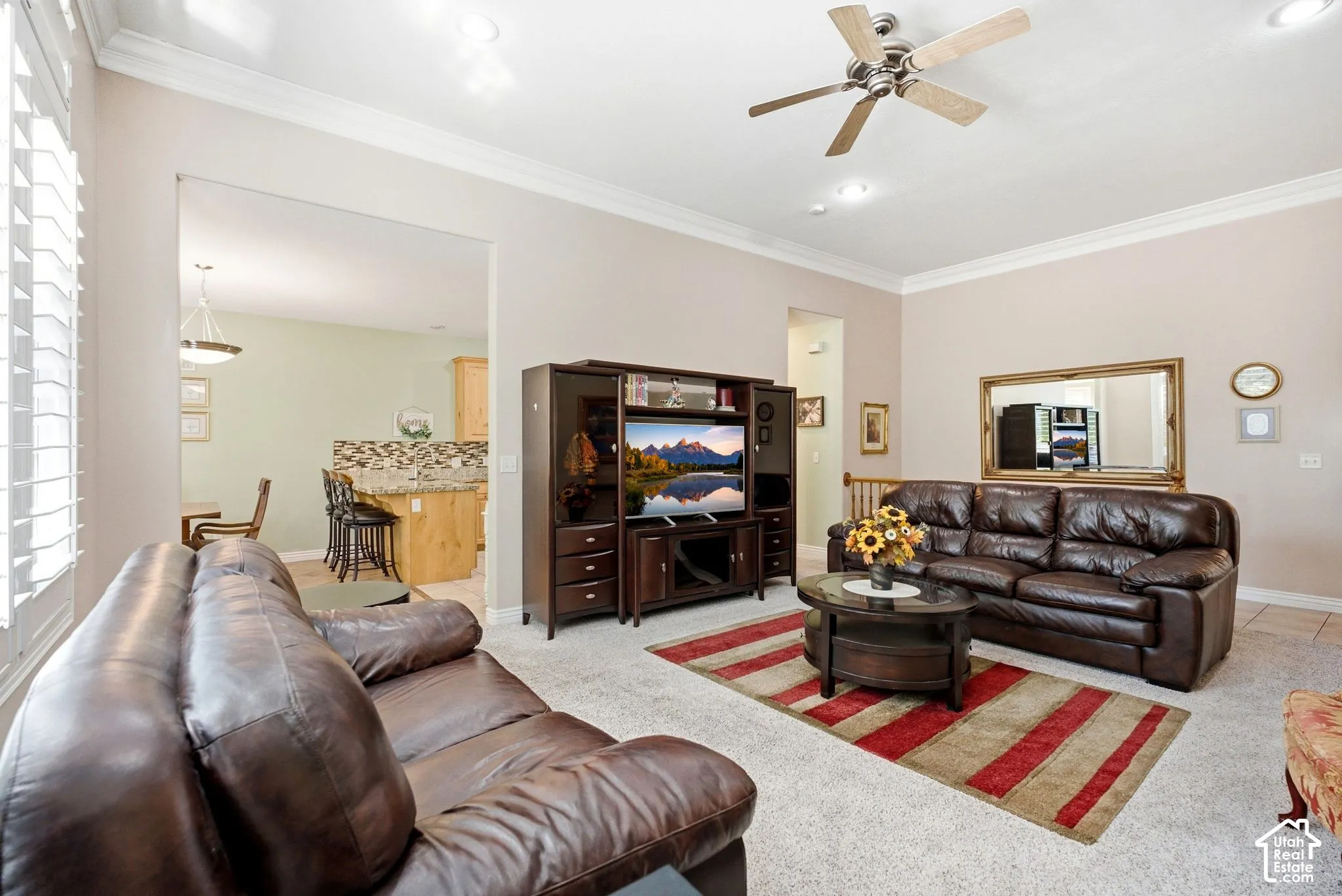 Carpeted living area with crown molding, recessed lighting, and a ceiling fan