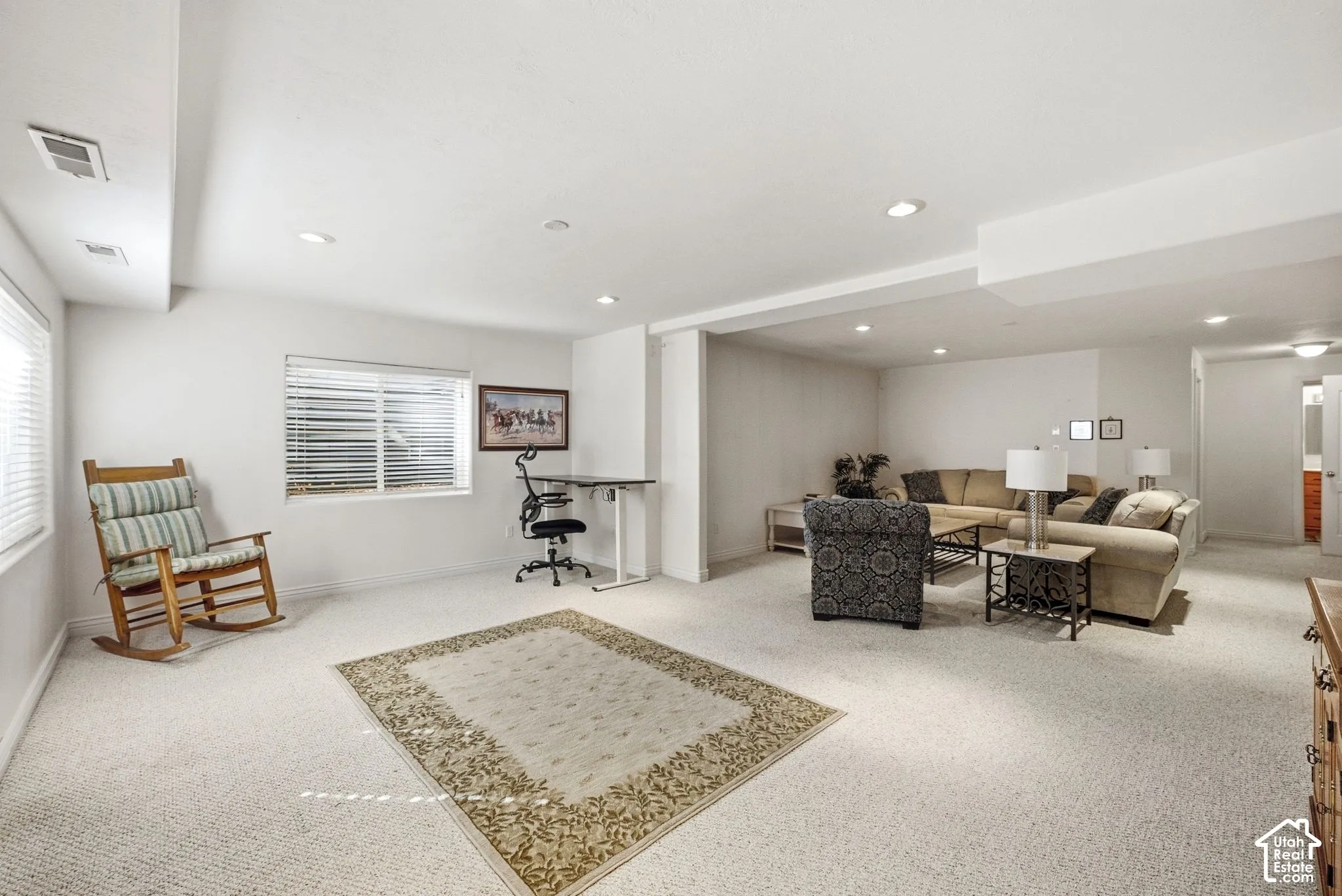 Spacious open-concept room with carpet flooring, recessed lighting, and multiple windows