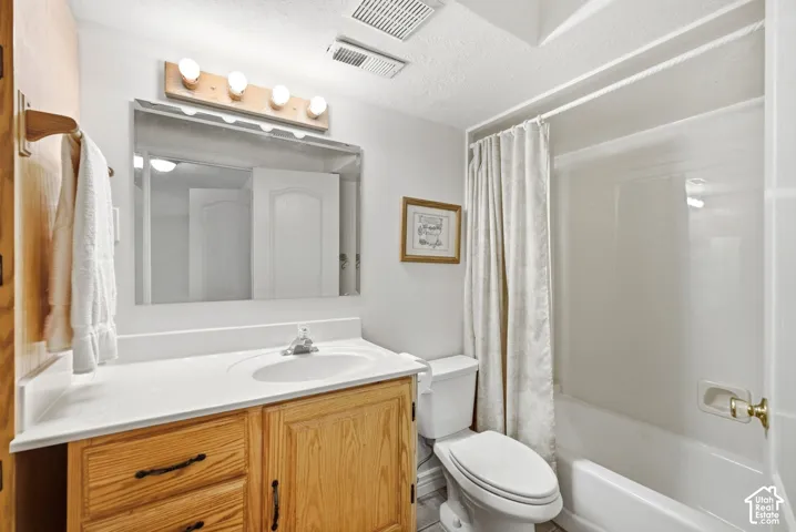 Vanity with wood-finish cabinetry, white countertop, and integrated sink