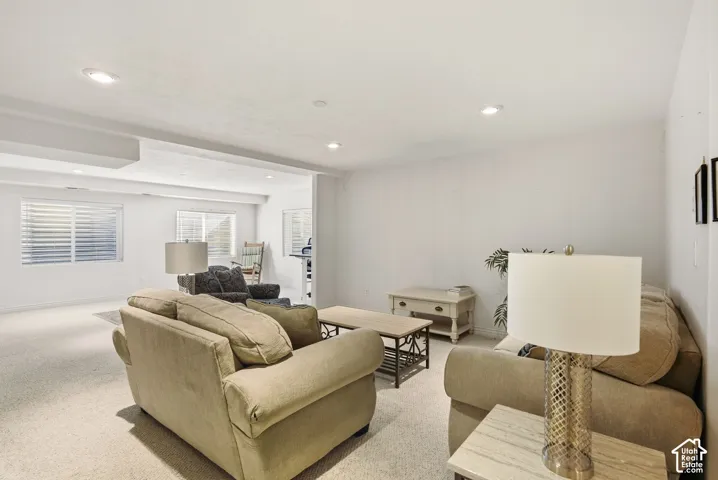 Recessed lighting, white walls, and carpet flooring create a bright atmosphere