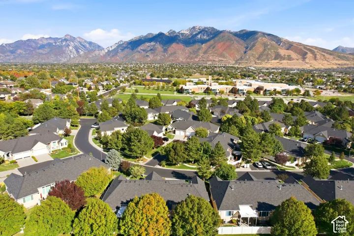 Residential neighborhood with mature trees, established landscaping, and mountain backdrop