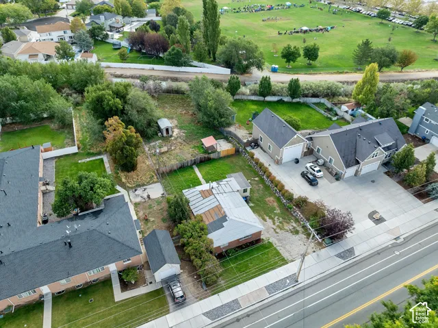 Expansive property featuring multiple structures, paved driveways, a detached garage, and mature trees
