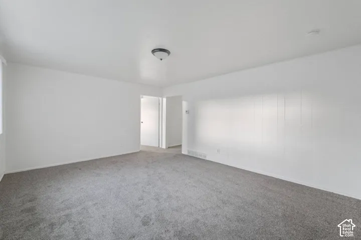 Spacious interior with neutral gray carpeting and white painted walls