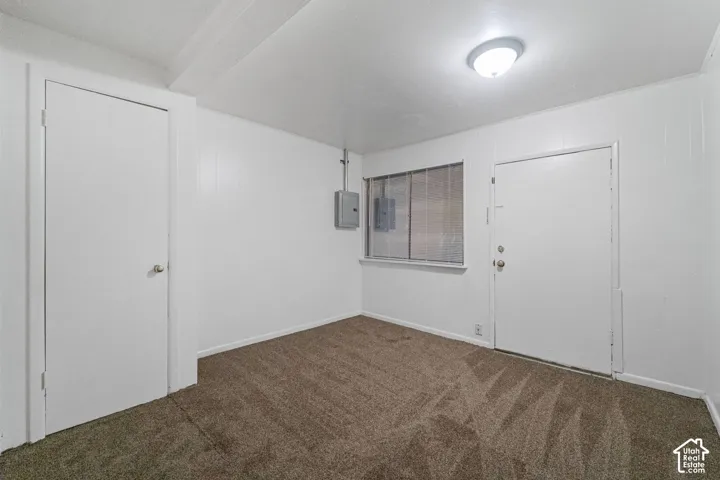 Room featuring carpet flooring, white walls, and a flush-mount ceiling light