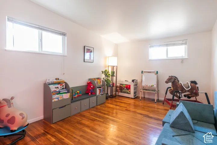 Wood-finish flooring, white walls, and multiple windows