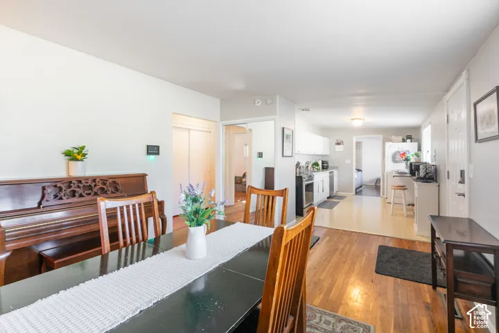 Hardwood flooring, white walls, and white kitchen cabinetry